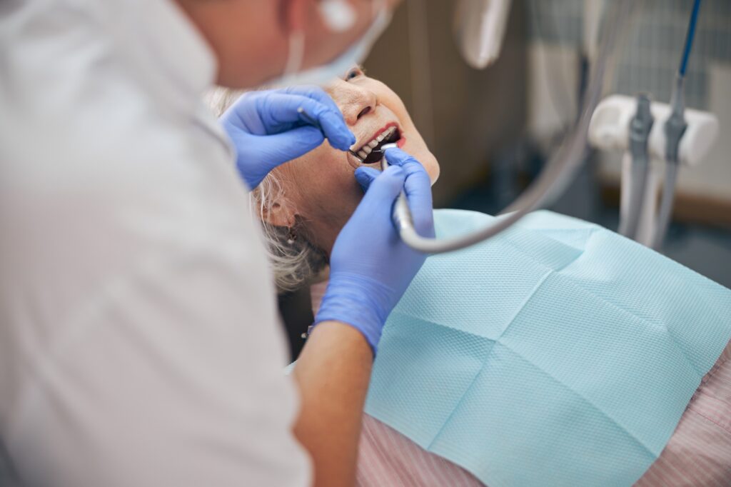 Male dentist working with dentist drill on patient